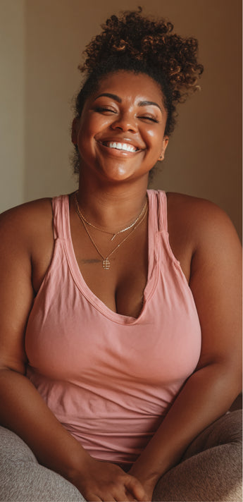 Woman in a pink tank top sitting and smiling