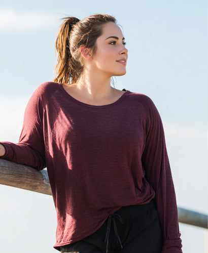 Woman in a long-sleeved top standing outdoors by a railing